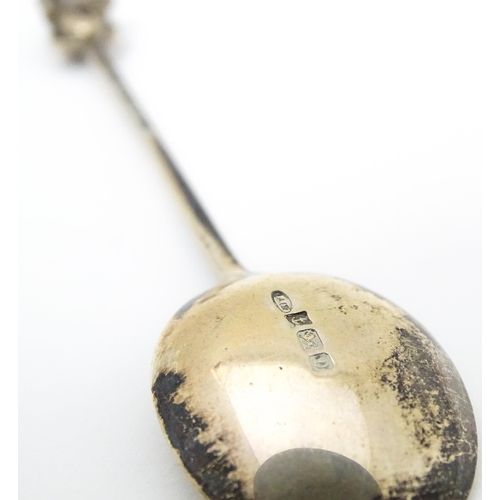 438 - Three silver teaspoons, one hallmarked Birmingham 1978, surmounted by a finial modelled as a turret ... 