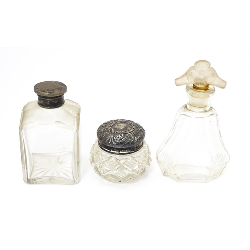 477 - Three various glass scent / dressing table bottles, one with Hallmarked silver top. The tallest 4 1/... 