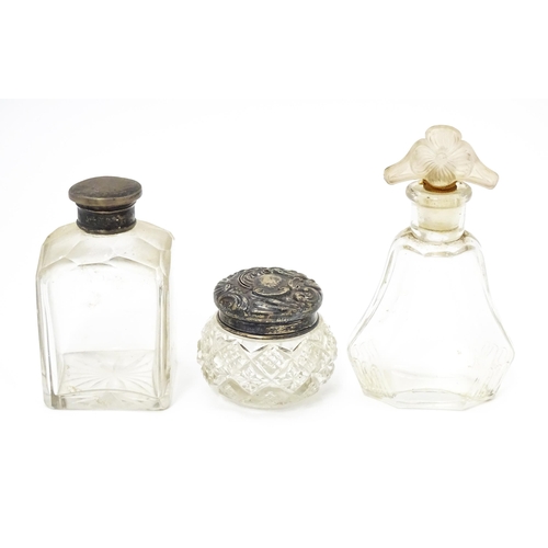 477 - Three various glass scent / dressing table bottles, one with Hallmarked silver top. The tallest 4 1/... 