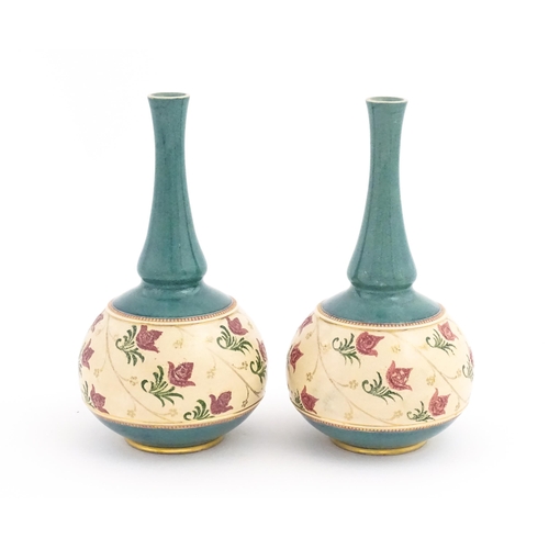 120 - A pair Royal Doulton bottle vases with turquoise ground and banded pink rose detail. Marked under. A... 