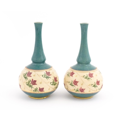 120 - A pair Royal Doulton bottle vases with turquoise ground and banded pink rose detail. Marked under. A... 