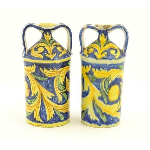 175 - Two Italian maiolica twin handled bottle jars, each decorated with foliate detail and a portrait bus... 