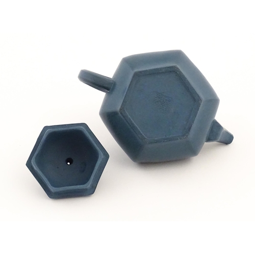 61 - A Chinese Yixing teapot of hexagonal form with a blue ground. Character marks under and to underside... 