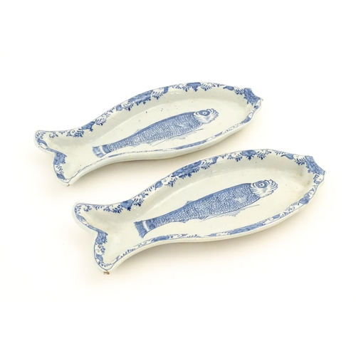 92 - Two Dutch Delft blue and white herring dishes of stylised fish form, with hand painted decoration de... 