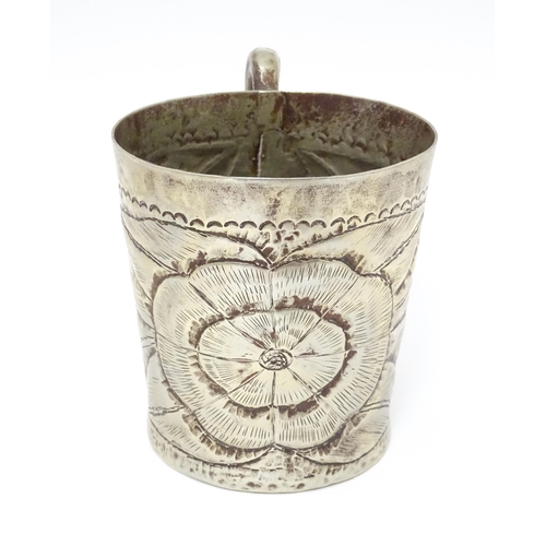 1005 - An Arts & Crafts silver plate mug with engraved flower / rose head decoration. Approx. 4