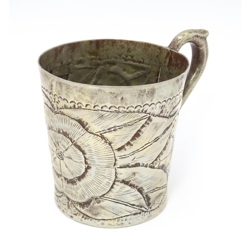 1005 - An Arts & Crafts silver plate mug with engraved flower / rose head decoration. Approx. 4