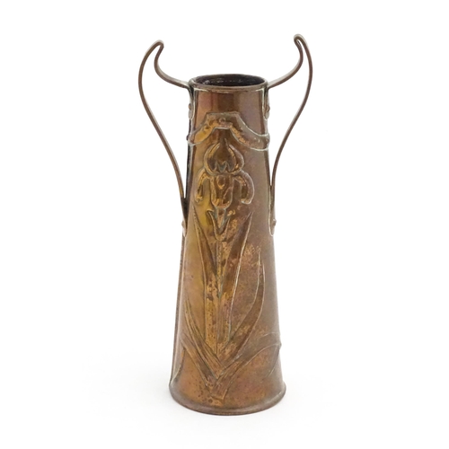 1006 - An Art Nouveau twin handled copper vase with embossed floral and foliate motifs. Approx. 11 1/4