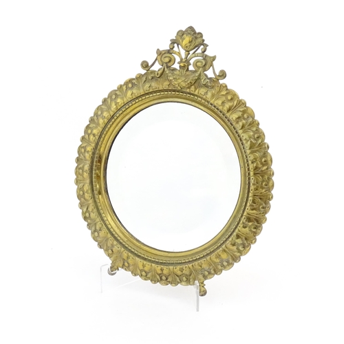 1023 - A late 19th / early 20thC mirror of circular form with bevelled glass, the brass frame with banded a... 