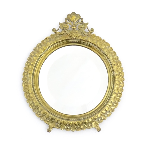 1023 - A late 19th / early 20thC mirror of circular form with bevelled glass, the brass frame with banded a... 