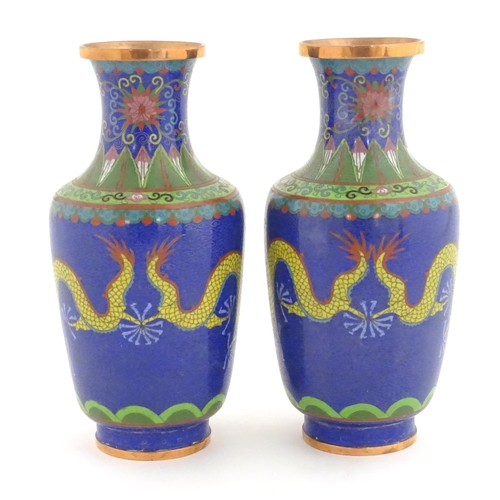 1026 - A pair of Oriental cloisonne vases decorated with two dragons and a flaming pearl amongst stylised c... 