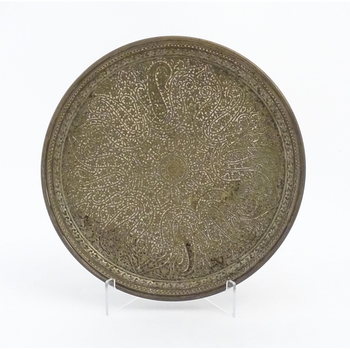 1046 - An Islamic cast charger decorated with floral motifs. Approx. 10