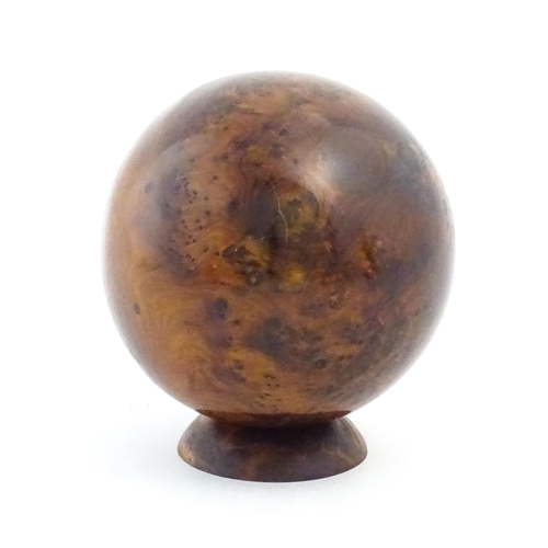 1059 - A 20thC burr yew wooden sphere / ball on a wooden base. Approx. 5 1/4