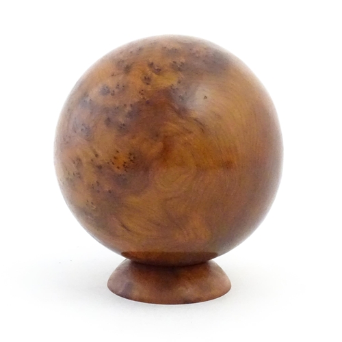 1059 - A 20thC burr yew wooden sphere / ball on a wooden base. Approx. 5 1/4