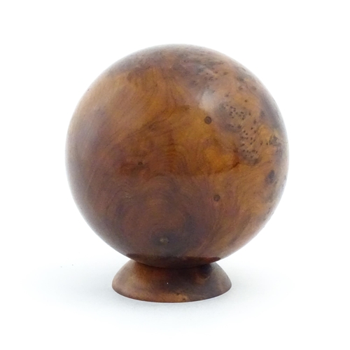 1059 - A 20thC burr yew wooden sphere / ball on a wooden base. Approx. 5 1/4