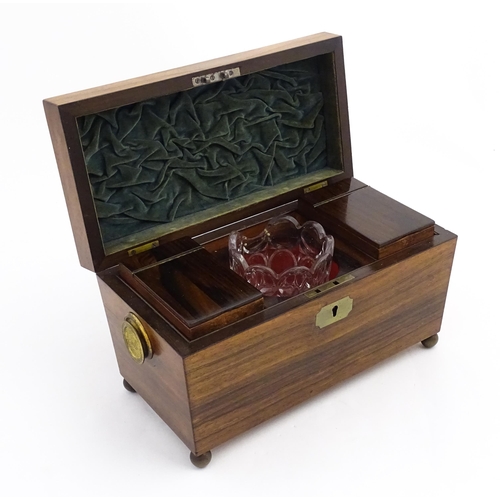 1062 - A 19thC rosewood tea caddy of sarcophagus form with twin roundel handles and ball feet. The interior... 