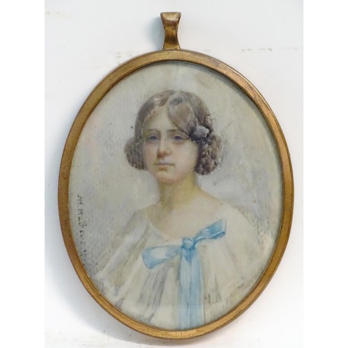 1155 - A 20thC watercolour portrait miniature depicting a seated young girl in a white dress with a blue bo... 