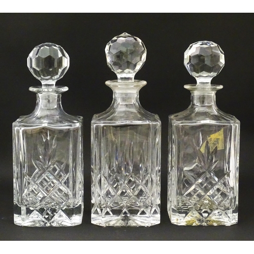 1231 - A 20thC mahogany tantalus with three cut glass decanters. Approx. 13