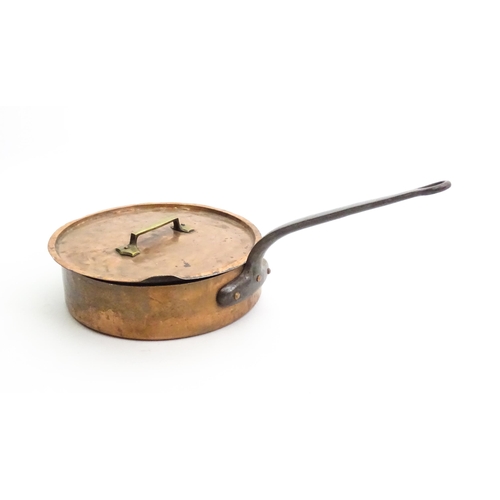 1235 - A large Continental copper saute pan with cast iron handle, the cover with a brass handle. Stamped S... 