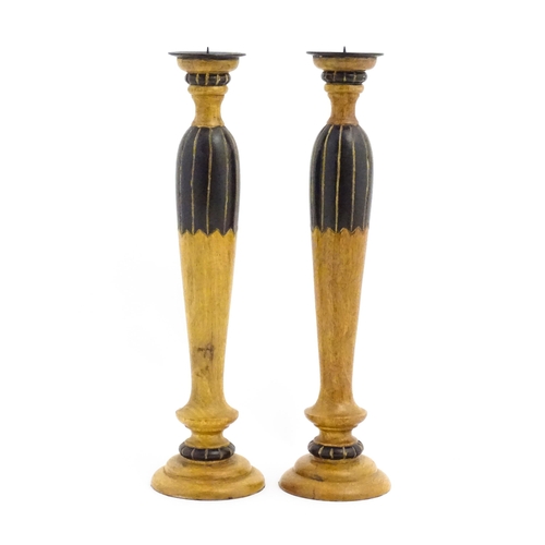 1240 - A pair of 20thC treen turned wooden candlesticks with painted and incised decoration. Approx. 14