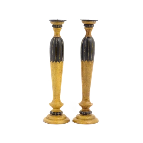 1240 - A pair of 20thC treen turned wooden candlesticks with painted and incised decoration. Approx. 14