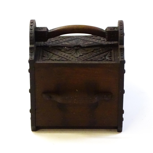 1261 - A 20thC carved coal scuttle with a shaped handle above a floral carved front and sides with lozenge ... 