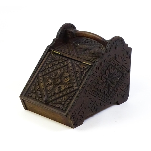 1261 - A 20thC carved coal scuttle with a shaped handle above a floral carved front and sides with lozenge ... 