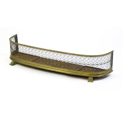 1263 - A 19thC brass fire fender with a bowed, pierced grill and iron base. 43