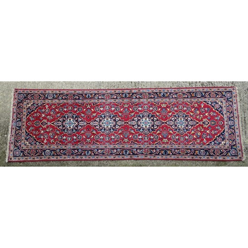 1273 - Carpet / Rug: A Central Persian kashan runner, the red ground with blue and cream ground motifs, flo... 