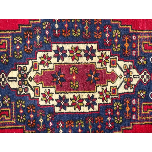 1278 - Carpet / Rug : A rug with red, blue and cream ground having central medallion with stylised floral d... 