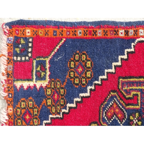 1278 - Carpet / Rug : A rug with red, blue and cream ground having central medallion with stylised floral d... 