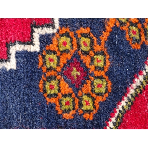 1278 - Carpet / Rug : A rug with red, blue and cream ground having central medallion with stylised floral d... 