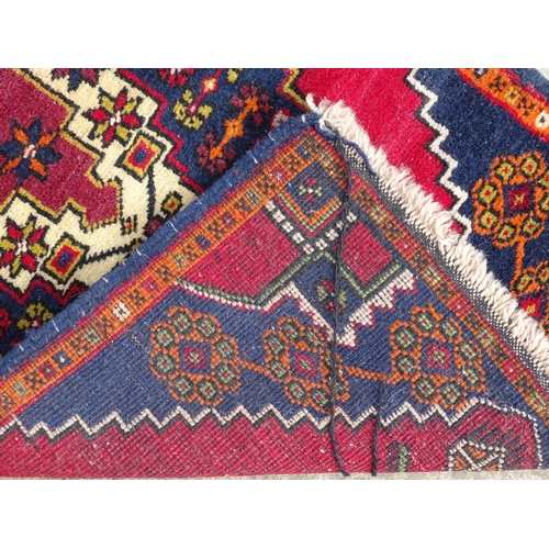 1278 - Carpet / Rug : A rug with red, blue and cream ground having central medallion with stylised floral d... 