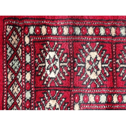 1279 - Carpet / Rug : A red ground rug with central repeated medallions further repeated medallions  to bor... 