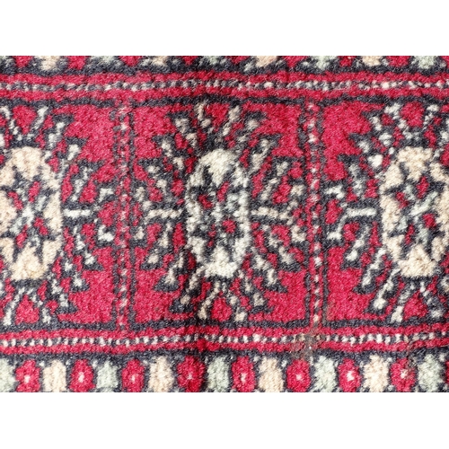 1279 - Carpet / Rug : A red ground rug with central repeated medallions further repeated medallions  to bor... 