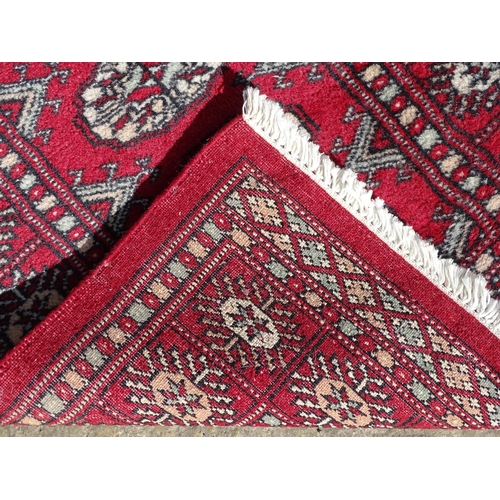 1279 - Carpet / Rug : A red ground rug with central repeated medallions further repeated medallions  to bor... 