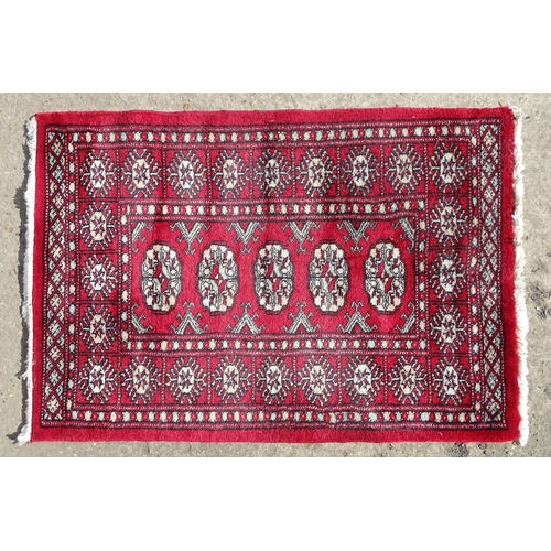 1279 - Carpet / Rug : A red ground rug with central repeated medallions further repeated medallions  to bor... 