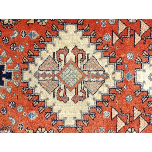 1282 - Carpet / Rug : A wool rug with central red ground with geometric medallions and stylised animal deta... 