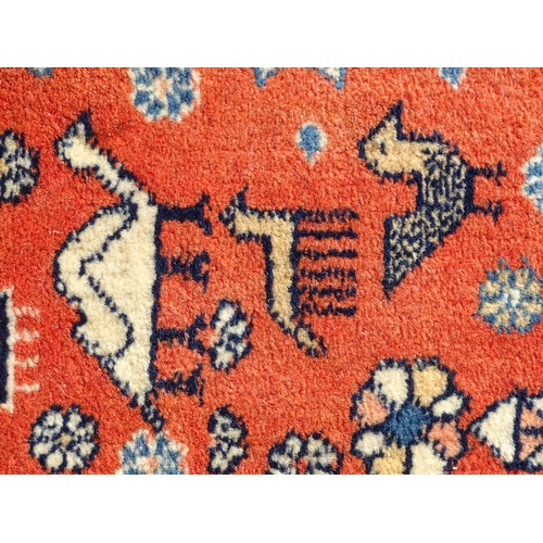 1282 - Carpet / Rug : A wool rug with central red ground with geometric medallions and stylised animal deta... 