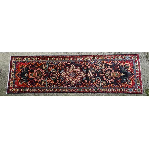 1283 - Carpet / Rug : A North west Persian Hamadam runner. The dark ground with floral and foliate motifs w... 