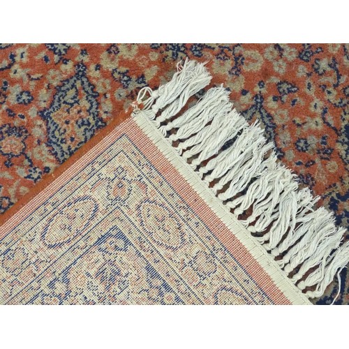 1286 - Carpet / Rug : An orange red ground rug with central medallions and floral detail. Approx 61