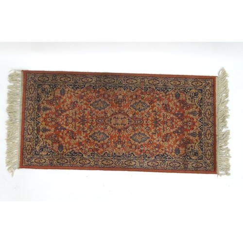 1286 - Carpet / Rug : An orange red ground rug with central medallions and floral detail. Approx 61