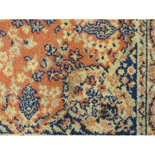 1286 - Carpet / Rug : An orange red ground rug with central medallions and floral detail. Approx 61