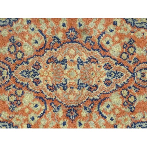 1286 - Carpet / Rug : An orange red ground rug with central medallions and floral detail. Approx 61