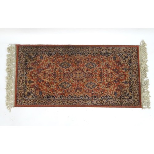 1286 - Carpet / Rug : An orange red ground rug with central medallions and floral detail. Approx 61