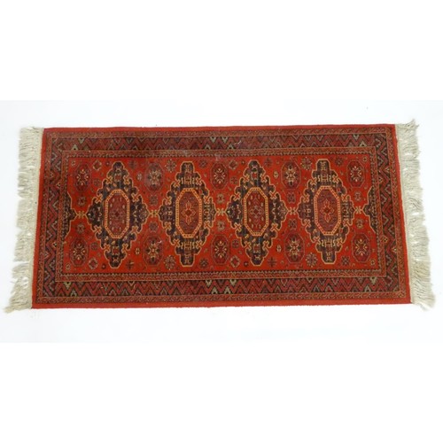 1288 - Carpet / Rug :  A red ground rug with four central medallions with geometric detail and border. Appr... 