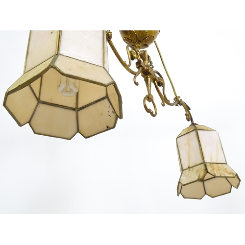 1310 - A 20thC twin pendant rise and fall ceiling lamp of scrolling form with twin shades. Approx 25