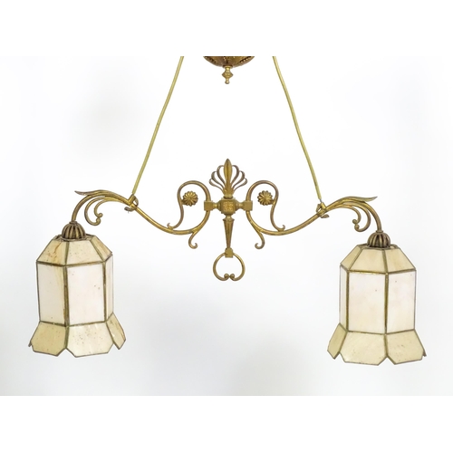 1310 - A 20thC twin pendant rise and fall ceiling lamp of scrolling form with twin shades. Approx 25