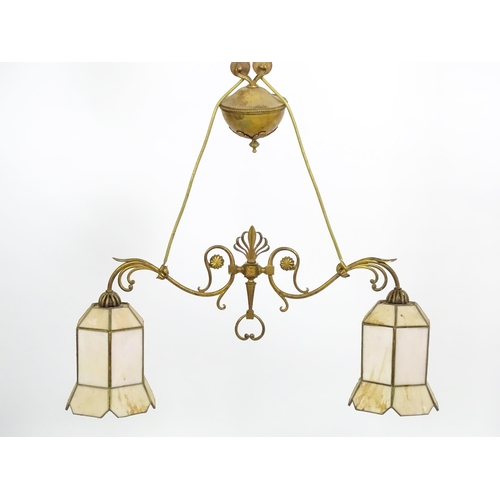 1310 - A 20thC twin pendant rise and fall ceiling lamp of scrolling form with twin shades. Approx 25