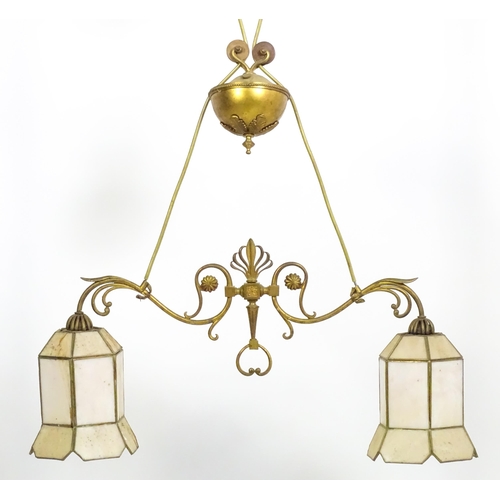 1310 - A 20thC twin pendant rise and fall ceiling lamp of scrolling form with twin shades. Approx 25