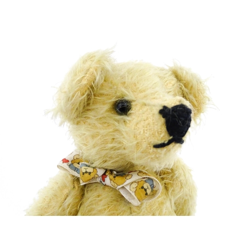 826 - Toy: A 20thC mohair teddy bear with stitched nose and mouth, pad paws, and articulated head and limb... 